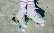 impala retro roller skates on pavement with tube socks that read 'impala skate'