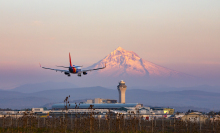 Southwest Airlines airplane flying near airport with mountain in background