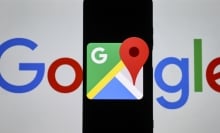 Google Maps logo displayed on a phone held in front of a Google logo.