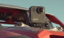 a GoPro Max camera sits mounted on the hood of a dusty car in the sun