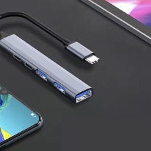 Mini 5-in-1 Type-C to USB Hub next to two phones.