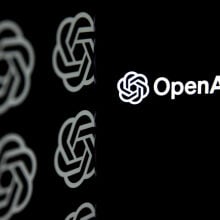 OpenAI logo is being displayed on a mobile phone screen in front of computer screen with the logo of ChatGPT.