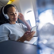 woman using headphones on an airplane