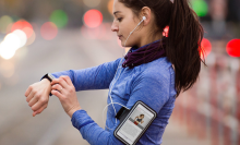 woman checking smartwatch on a run