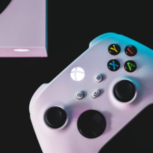 Xbox controller and console against a black backdrop