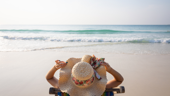 woman laying on beach in sun hat